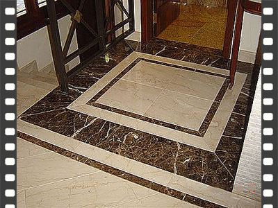 Detalhe de piso de granito polido com bordas em mármore preto