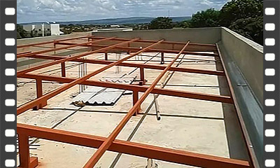 Cobertura com telha metálica fixada em estrutura de madeira sobre laje de concreto