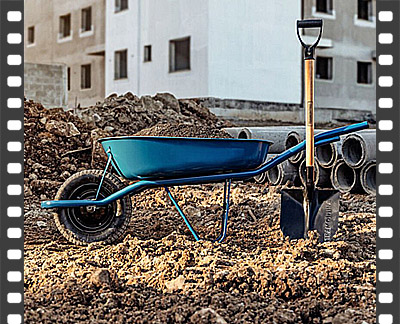 Transporte manual de terra em carrinho de mão dentro do canteiro de obras